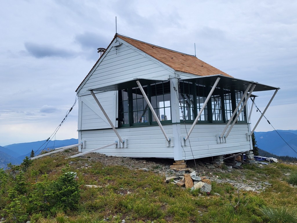 A lookout on top of a mountain with open shutters.
